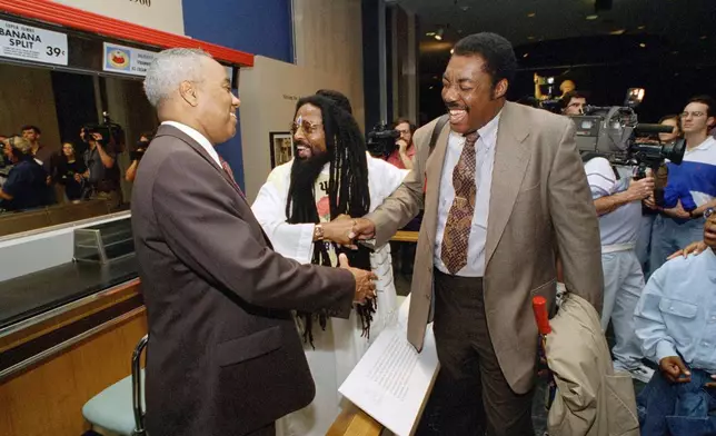 FILE - From left: Joseph McNeil, Jibreel Khazan, and Franklin McCain greet each other during an opening of a new exhibit at the Smithsonian Institution's National Museum of American History in Washington, Jan. 14, 1995. (AP Photo/Tyler Mallory, File)