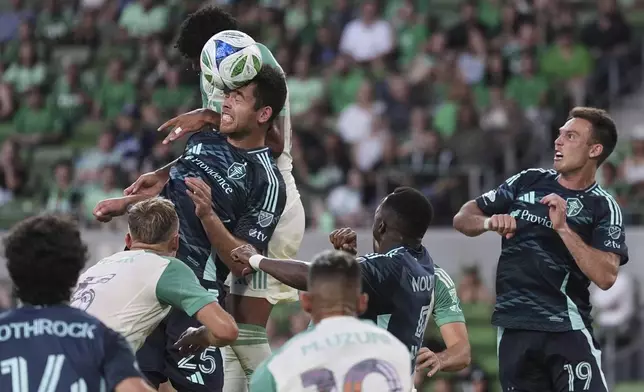 Seattle Sounders' Jackson Ragen (25) heads the ball to block a pass in front of Austin FC's Owen Wolff, back center, during the second half of an MLS soccer match in Austin, Texas, Sunday, Sept. 21, 2025. (AP Photo/Eric Gay)