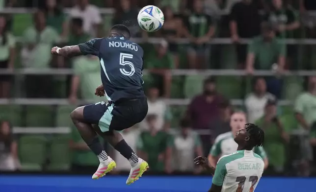 Seattle Sounders' Nouhou Tolo (5) heads a pass over Austin FC midfielder Samuel Gustafson (11) during the second half of an MLS soccer match in Austin, Texas, Sunday, Sept. 21, 2025. (AP Photo/Eric Gay)