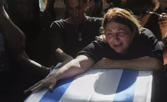 Dalit Shtivi mourns over the coffin of her son, slain hostage Idan Shtivi, whose body was recovered in an Israeli military operation in the Gaza Strip, during his funeral in Kfar Maas, Israel, Monday, Sept. 1, 2025. (AP Photo/Ariel Schalit)