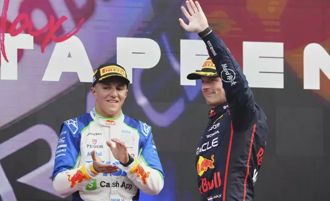 Third-placed Racing Bulls driver Isack Hadjar of France, left, and second-placed Red Bull driver Max Verstappen of the Netherlands stand on the podium during the Formula One Dutch Grand Prix in Zandvoort, Netherlands, Sunday, Aug. 31, 2025. (AP Photo/Peter Dejong)
