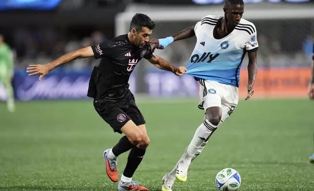 Inter Miami midfielder Sergio Busquets (5) defends against Charlotte FC midfielder Djibril Diani (28) during the first half of an MLS soccer match, Saturday, Sept. 13, 2025, in Charlotte, N.C. (AP Photo/Erik Verduzco)