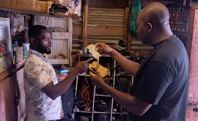 A customer pays for a service with perforated notes, which are rejected in Bukavu, Democratic Republic of the Congo, Friday, Aug 29, 2025. (AP Photo)