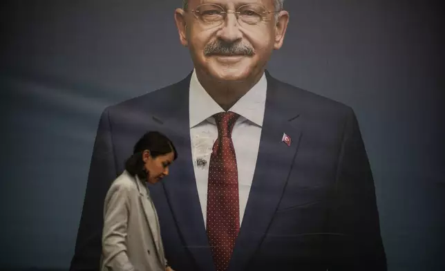 FILE - A woman walks past a billboard of then Turkish CHP party leader Kemal Kilicdaroglu in Istanbul, Turkey. (AP Photo/Emrah Gurel, File)
