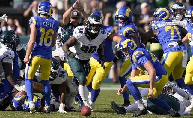 Philadelphia Eagles defensive tackle Jordan Davis (90) prepares to pick up the ball after blocking a field goal attempt by Los Angeles Rams kicker Joshua Karty (16) and run the ball back for a touchdown as time expires during the second half of an NFL football game against the Los Angeles Rams Sunday, Sept. 21, 2025, in Philadelphia. (AP Photo/Chris Szagola)