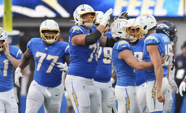 Los Angeles Chargers kicker Cameron Dicker (11) celebrates his game-winning field goal with teammates in an NFL football game against the Denver Broncos, Sunday, Sept. 21, 2025, in Inglewood, Calif. (AP Photo/Gregory Bull)