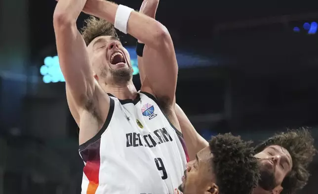 Portugal's Travante Williams, centre, in action against Germany's Franz Wagner during the Eurobasket, European Basketball Championship round of 16 match between Germany and Portugal at the Riga Arena in Riga, Latvia, Saturday, Sept. 6, 2025. (AP Photo/Sergei Grits)