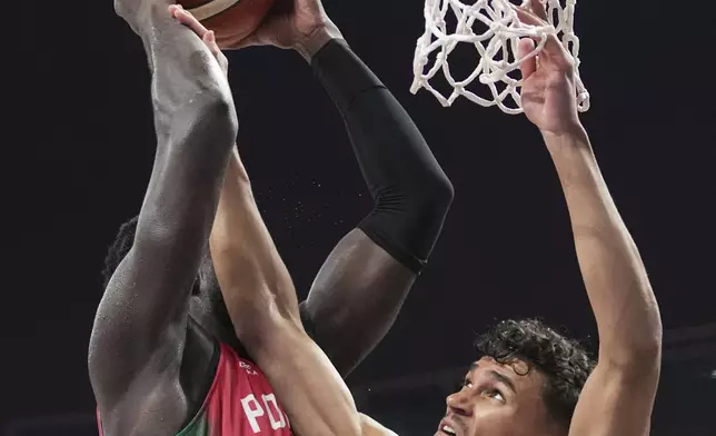 Portugal's Neemias Queta, left, tries to shoot while defended by Germany's Tristan Da Silva during the Eurobasket, European Basketball Championship round of 16 match between Germany and Portugal at the Riga Arena in Riga, Latvia, Saturday, Sept. 6, 2025. (AP Photo/Sergei Grits)
