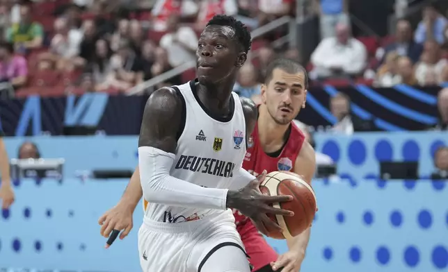 Germany's Dennis Schroder and Portugal's Diogo Gameiro in action during the Eurobasket, European Basketball Championship round of 16 match between Germany and Portugal at the Riga Arena in Riga, Latvia, Saturday, Sept. 6, 2025. (AP Photo/Sergei Grits)