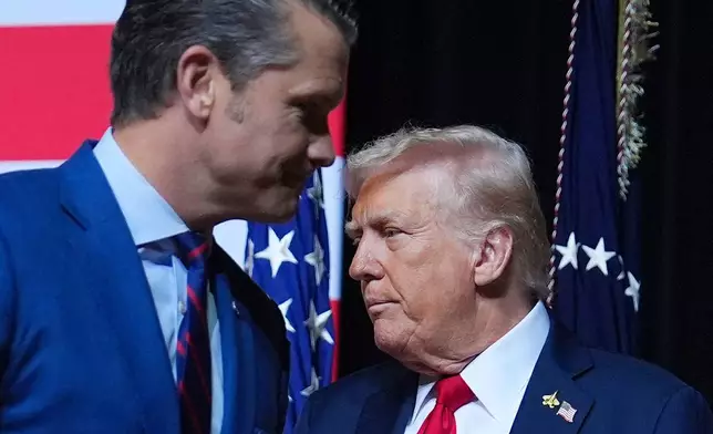 President Donald Trump is greeted by Secretary of Defense Pete Hegseth before speaking to a gathering of top U.S. military commanders at Marine Corps Base Quantico, Tuesday, Sept. 30, 2025, in Quantico, Va. (AP Photo/Evan Vucci)