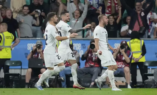 Slovenian players celebrate after a goal during the World Cup qualifying soccer match between Slovenia and Sweden at the Stozice stadium in Ljubljana, Slovenia, Friday, Sept. 5, 2025. (AP Photo/Darko Bandic)