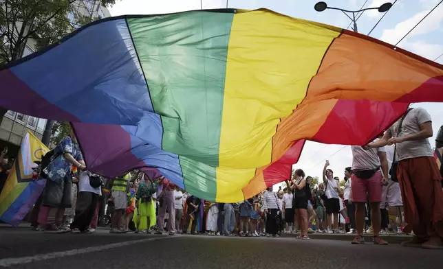 Participants hold up a rainbow flag during the Gay Pride march in Belgrade, Serbia, Saturday, Sept. 6, 2025. (AP Photo/Darko Vojinovic)