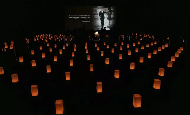 People pay their respects to fashion designer Giorgio Armani, lying in state at the Armani/Teatro in Milan, northern Italy, Saturday, Sept. 6, 2025. (AP Photo/Antonio Calanni)