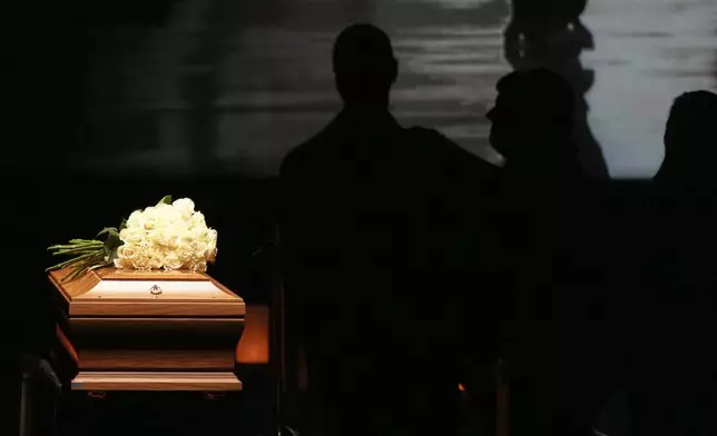 People pay their respects to fashion designer Giorgio Armani, lying in state at the Armani/Teatro in Milan, northern Italy, Saturday, Sept. 6, 2025. (AP Photo/Antonio Calanni)