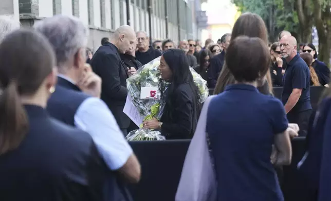 People line up in Milan, northern Italy, Thursday, Sept. 4, 2025, to pay their respects to fashion designer Giorgio Armani, who died Thursday at age 91. (AP Photo/Antonio Calanni)