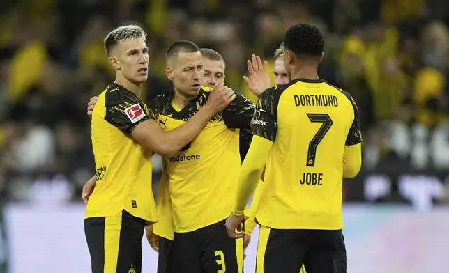 Dortmund players celebrate at the end of the German Bundesliga soccer match between Borussia Dortmund and VfL Wolfsburg in Dortmund, Germany, Sunday, Sept. 21, 2025. (AP Photo/Martin Meissner)