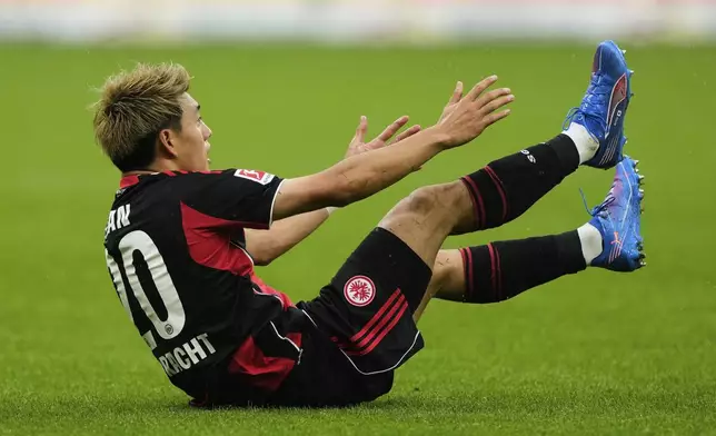 Frankfurt's Ritsu Doan is on the ground during a German Bundesliga soccer match between Eintracht Frankfurt and Union Berlin in Frankfurt, Germany, Sunday, Sept. 21, 2025. (AP Photo/Michael Probst)