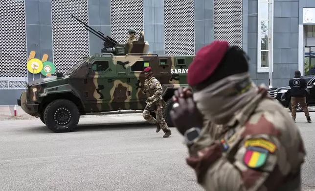 Guinean soldiers secure the area outside a polling station before Gen. Mamadi Doumbouya arrives to cast his vote in the constitutional referendum, in Conakry, Guinea, Sunday, Sept. 21, 2025. (AP Photo/Misper Apawu)