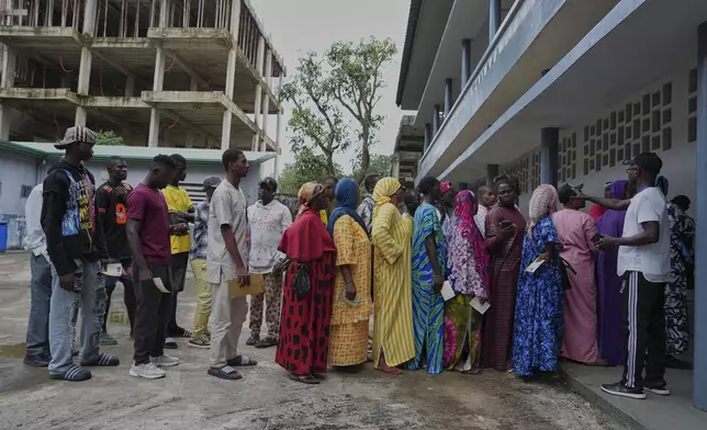 Voters queue to cast their votes in the constitutional referendum, in Conakry, Guinea, Sunday, Sept. 21, 2025. (AP Photo/Misper Apawu)
