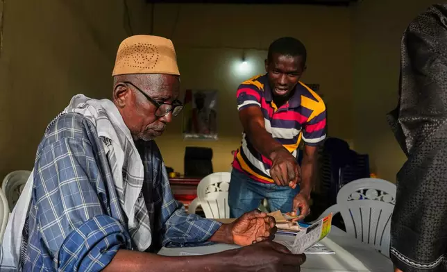 Officials work at a polling station during the constitutional referendum in Conakry, Guinea, Sunday, Sept. 21, 2025. (AP Photo/Misper Apawu)
