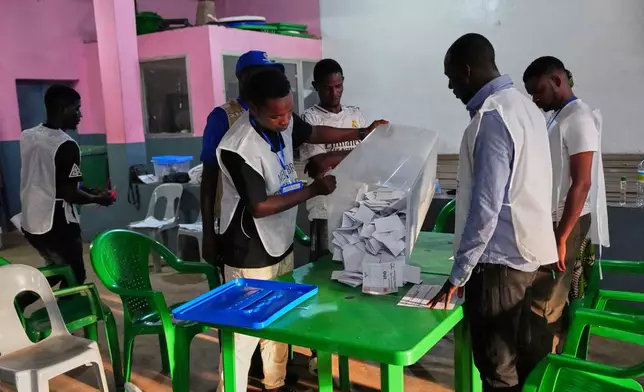 Voting slips are emptied from a ballot box at a polling station as polls close during the constitutional referendum in Conakry, Guinea, Sunday, Sept. 21, 2025. (AP Photo/Misper Apawu)
