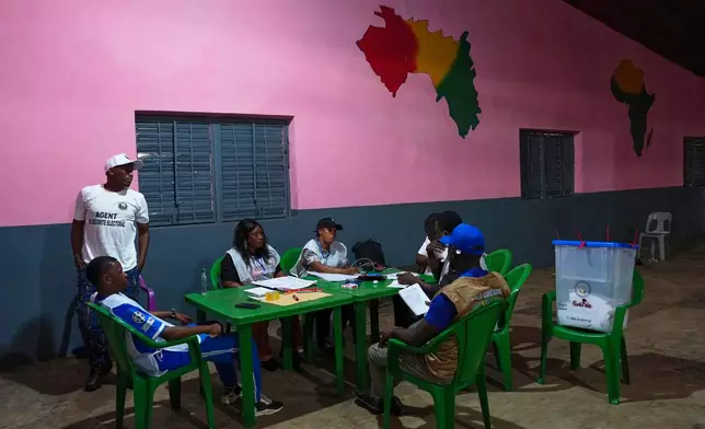 Officials wait at a polling station as polls close during the constitutional referendum in Conakry, Guinea, Sunday, Sept. 21, 2025. (AP Photo/Misper Apawu)