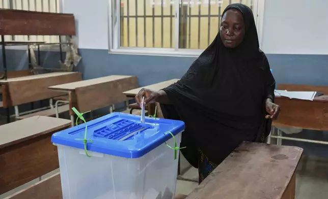 A woman casts her ballot during the constitutional referendum in Conakry, Guinea, Sunday, Sept. 21, 2025. (AP Photo/Misper Apawu)