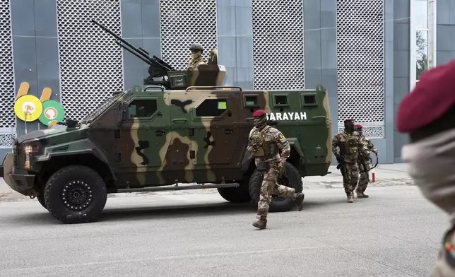 Guinean soldiers secure the area outside a polling station before Gen. Mamadi Doumbouya arrives to cast his vote in the constitutional referendum, in Conakry, Guinea, Sunday, Sept. 21, 2025. (AP Photo/Misper Apawu)