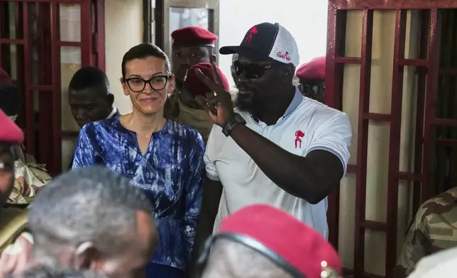 Guinea's interim President, Gen. Mamadi Doumbouya, departs with his wife after casting his vote in the constitutional referendum in Conakry, Guinea, Sunday, Sept. 21, 2025. (AP Photo/Misper Apawu)