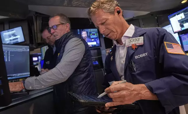 Trader Robert Charmak, right, and specialist Glenn Carell, center, work on the floor of the New York Stock Exchange, Wednesday, Sept. 10, 2025. (AP Photo/Richard Drew)