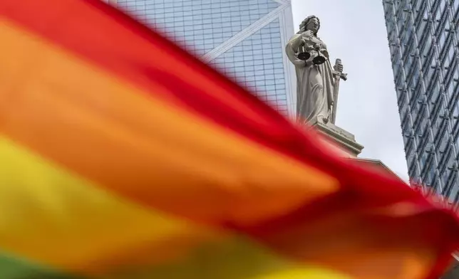 A rainbow flag is posed for photos in front of the court of final appeal in Hong Kong, Sunday, Aug. 24, 2025. (AP Photo/Chan Long Hei)