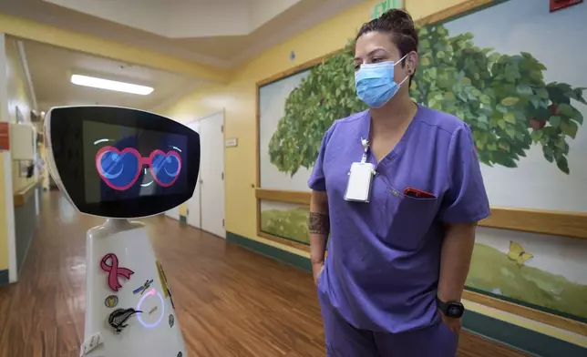 Activities Coordinator Melissa Delaney interacts with Robin the Robot as it visits patients' rooms at the HealthBridge Orange Specialty Pediatric Hospital in Orange, Calif., on Friday, Sept. 12, 2025. (AP Photo/Damian Dovarganes)