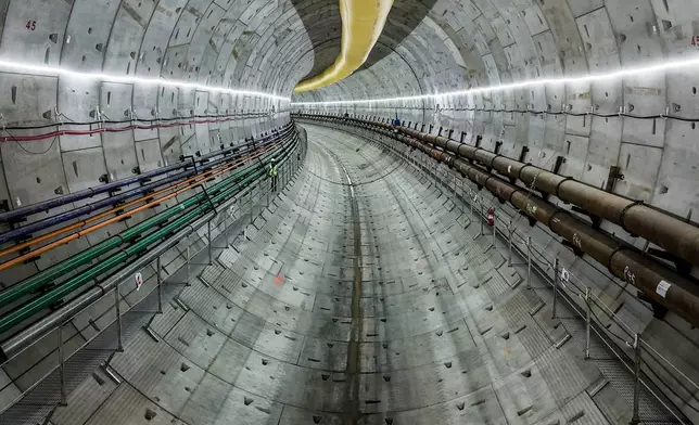 A construction worker makes his way along a track-level walkway in the metro tunnel beneath the Panama Canal during a media tour, in Arraijan, west of Panama City, Tuesday, Sept. 23, 2025. (AP Photo/Matias Delacroix)