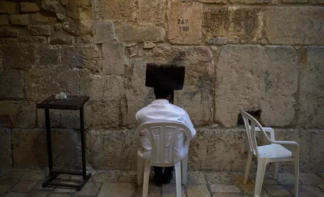 An Ultra-Orthodox Jewish man prays at the Little Western Wall during Rosh Hashanah celebrations, the Jewish New Year, in the Old City of Jerusalem, Tuesday, Sept. 23, 2025. (AP Photo/Leo Correa)