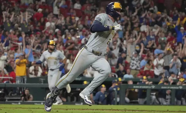 Milwaukee Brewers' Brice Turang, right, singles as Jackson Chourio, left, jogs in to score during the 10th inning of a baseball game against the St. Louis Cardinals Saturday, Sept. 20, 2025, in St. Louis. (AP Photo/Jeff Roberson)