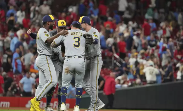 Members of the Milwaukee Brewers celebrate a victory over the St. Louis Cardinals following a baseball game Saturday, Sept. 20, 2025, in St. Louis. (AP Photo/Jeff Roberson)
