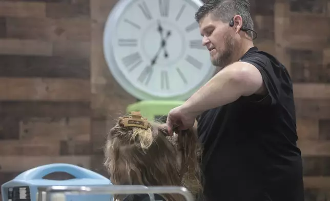 Jacob Anthon demonstrates the use of an FDA-cleared device that uses a combination of airflow temperature, speed, and direction to kill lice and eggs at Lice Clinics of America in Sugar Land, Texas, Monday, Sept. 22, 2025. (AP Photo/Lekan Oyekanmi)