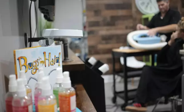 Jacob Anthon demonstrates the use of an FDA-cleared device that uses a combination of airflow temperature, speed, and direction to kill lice and eggs at Lice Clinics of America in Sugar Land, Texas, Monday, Sept. 22, 2025. (AP Photo/Lekan Oyekanmi)