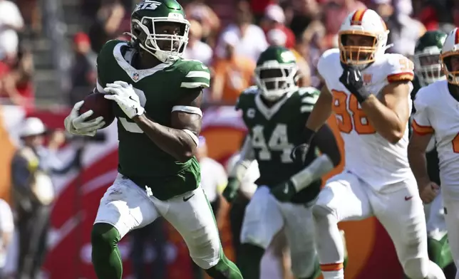 New York Jets defensive end Will McDonald IV (9) runs for a touchdown after blocking a field goal during the second half of an NFL football game against the Tampa Bay Buccaneers Sunday, Sept. 21, 2025, in Tampa, Fla. (AP Photo/Jason Behnken)