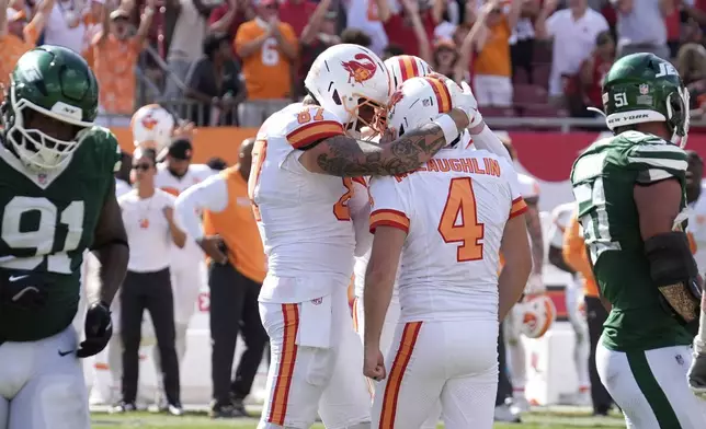 Tampa Bay Buccaneers kicker Chase McLaughlin (4) is hugged by his teammates after scoring a field goal to win the game during the second half of an NFL football game against the New York Jets Sunday, Sept. 21, 2025, in Tampa, Fla. (AP Photo/Chris O'Meara)