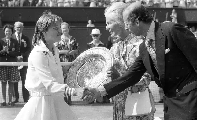 FILE - Chris Evert shakes hands with the Duke of Kent, right, while the Duchess of Kent, presents her with the winner's trophy, after she beat Australia's Evonne Goolagong Cawley in the final of the Women's Singles championship on July 2, 1976. (AP Photo/Bob Dear, File)