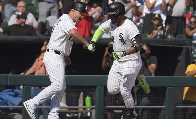 Chicago White Sox's Lenyn Sosa, right, celebrates with third base coach Justin Jirschele, left, after hitting a solo home run during the eighth inning of a baseball game against the New York Yankees in Chicago, Sunday, Aug. 31, 2025. (AP Photo/Nam Y. Huh)