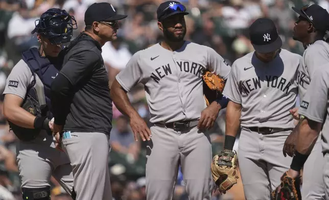 New York Yankees manager Aaron Boone, second from left, talks to players during the sixth inning of a baseball game against the Chicago White Sox in Chicago, Sunday, Aug. 31, 2025. (AP Photo/Nam Y. Huh)