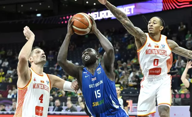 Montenegro's Nikola Vucevic, left, and Kyle Allman Jr., right, challenge for the ball with Britain's Akwasi Yeboah, center, during the Eurobasket, European Basketball Championship, group B match between Montenegro and Great Britain in Tampere, Finland, Wednesday, Sept. 3, 2025. (Heikki Saukkomaa/Lehtikuva via AP)