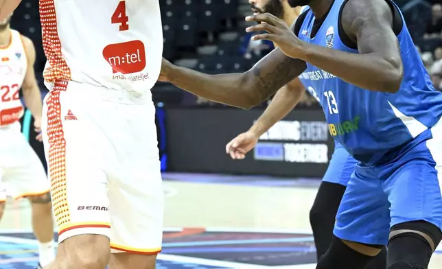 Britain's Jubrile Belo, right, and Montenegro's Nikola Vucevic, left, challenge for the ball during the Eurobasket, European Basketball Championship, group B match between Montenegro and Great Britain in Tampere, Finland, Wednesday, Sept. 3, 2025. (Heikki Saukkomaa/Lehtikuva via AP)