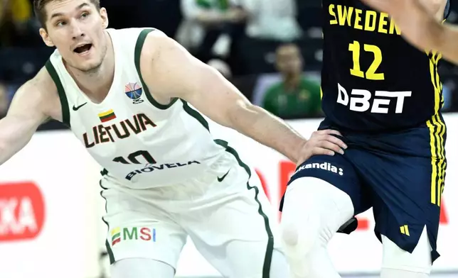 Sweden's Ludvig Hakanson, right, and Lithuania's Azuolas Tubelis, left, challenge for the ball during the Eurobasket, European Basketball Championship, group B match between Lithuania and Sweden in Tampere, Finland, Wednesday, Sept. 3, 2025. (Heikki Saukkomaa/Lehtikuva via AP)