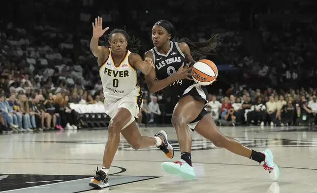Las Vegas Aces guard Jackie Young, right, drives past Indiana Fever guard Kelsey Mitchell, left, in the first half of Game 1 of a WNBA basketball playoff semifinals series Sunday, Sept. 21, 2025, in Las Vegas. (AP Photo/Candice Ward)