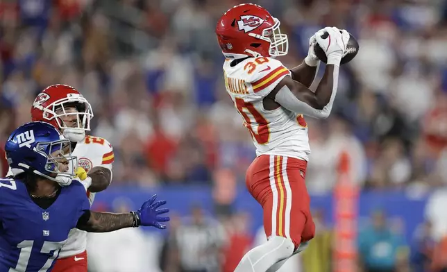 Kansas City Chiefs cornerback Chris Roland-Wallace (30) intercepts a pass intended for New York Giants wide receiver Wan'Dale Robinson (17) as Chiefs cornerback Trent McDuffie watches during the first half of an NFL football game Sunday, Sept. 21, 2025, in East Rutherford, N.J. (AP Photo/Adam Hunger)