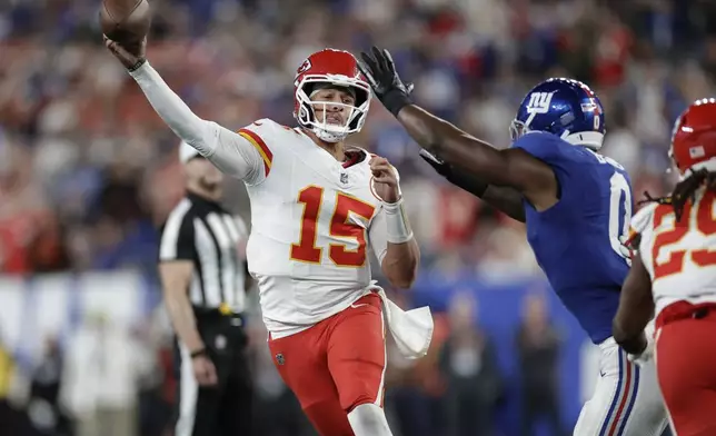 Kansas City Chiefs quarterback Patrick Mahomes (15) throws under pressure from New York Giants outside linebacker Brian Burns (0) during the first half of an NFL football game Sunday, Sept. 21, 2025, in East Rutherford, N.J. (AP Photo/Adam Hunger)