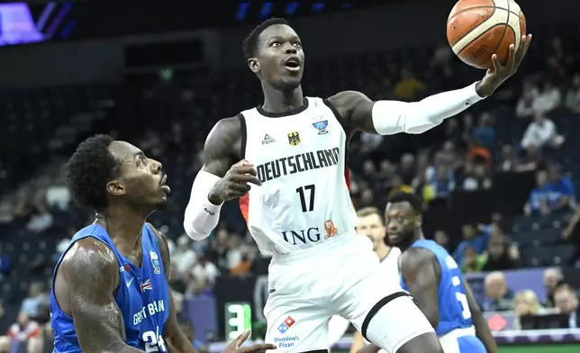 Britain's Carl Wheatle, left, and Germany's Dennis Schroeder, right, challenge for the ball during the Eurobasket, European Basketball Championship, group B match between Germany and Great Britain in Tampere, Finland, Monday, Sept. 1, 2025. (Heikki Saukkomaa/Lehtikuva via AP)